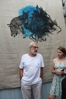 Сергей Цигаль на фоне своей работы «Коты» (шелкография на холсте) 