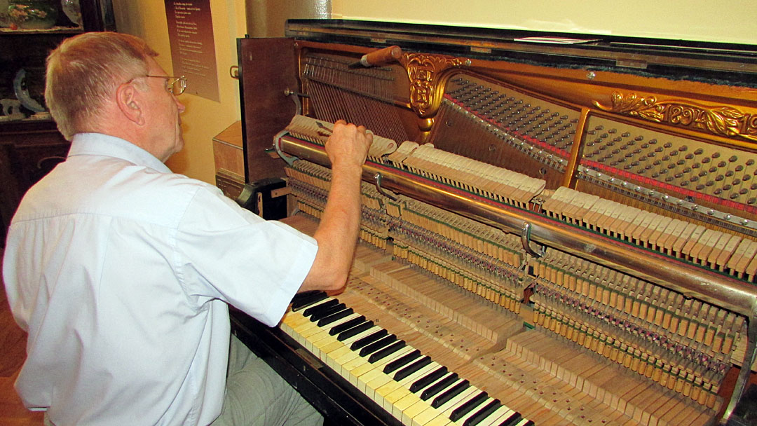 Настройщик фортепиано Александр Родионов за работой над музейным музыкальным инструментом.